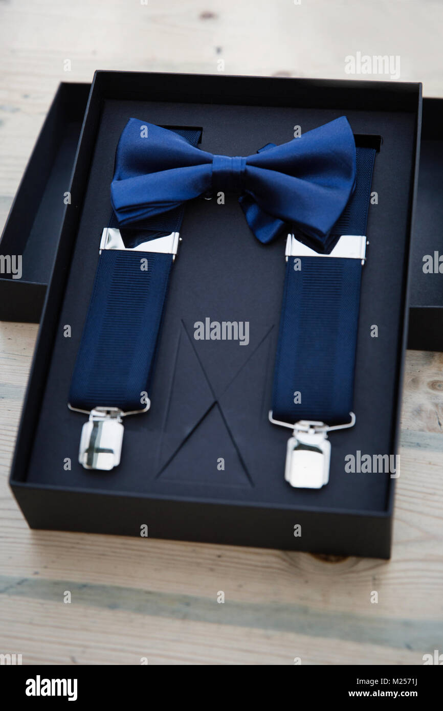 Blue bow tie and mens trouser braces in gift box, overhead view Stock Photo
