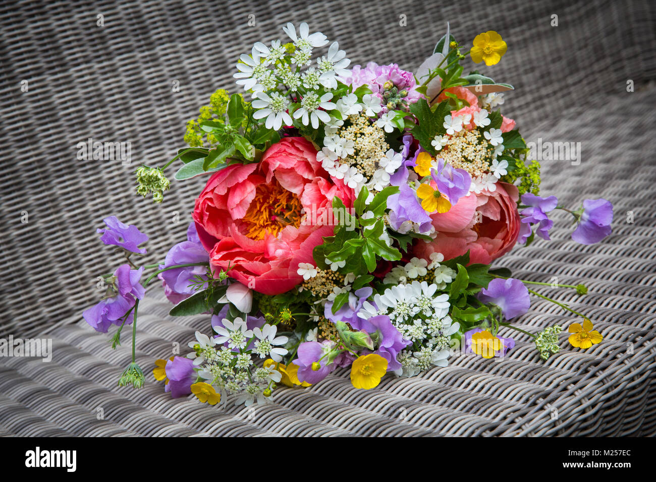 Colourful flower bouquet with peony rose and buttercups on wickerwork Stock Photo