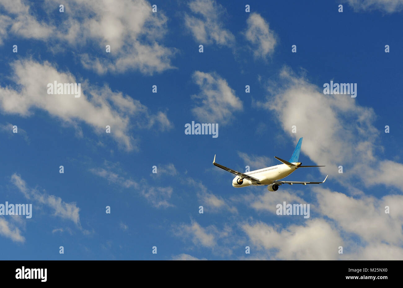 Flying airplane in the blue sky Stock Photo - Alamy