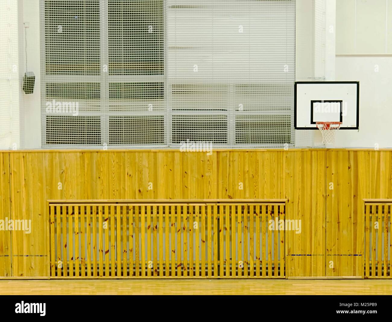 View of Interior of school gym with walls covered by safety net. Large hall ...