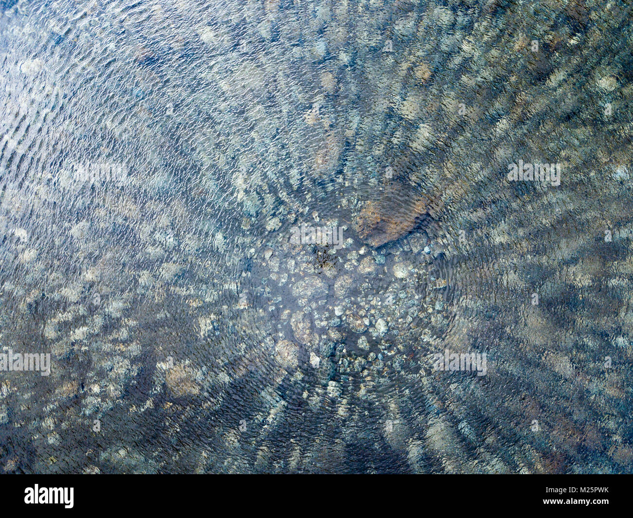 Aerial view of transparent water of a mountain lake, pebbles and rocks on the river bed Stock Photo