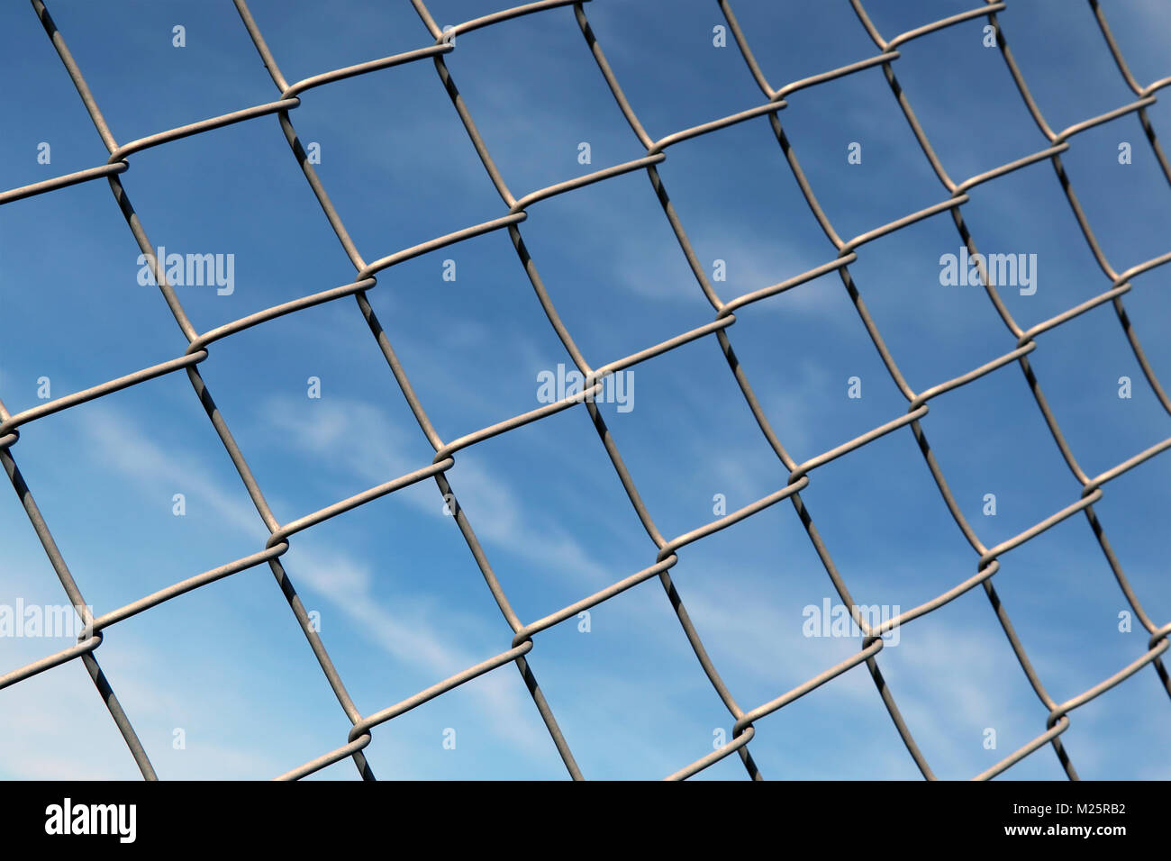 Chain linked fence with blue sky as background. Stock Photo