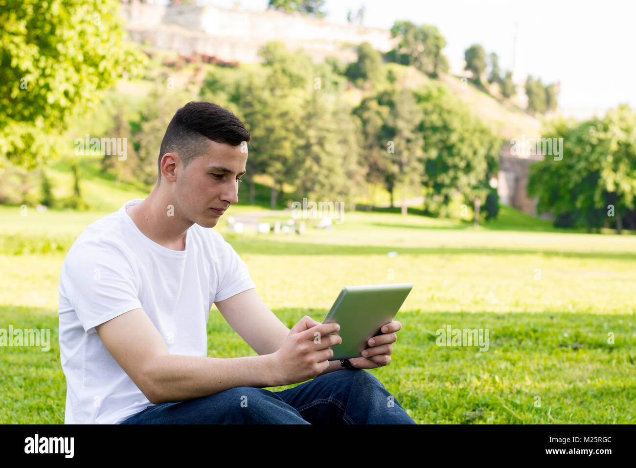 Boy using digital tablet with park in background Stock Photo - Alamy