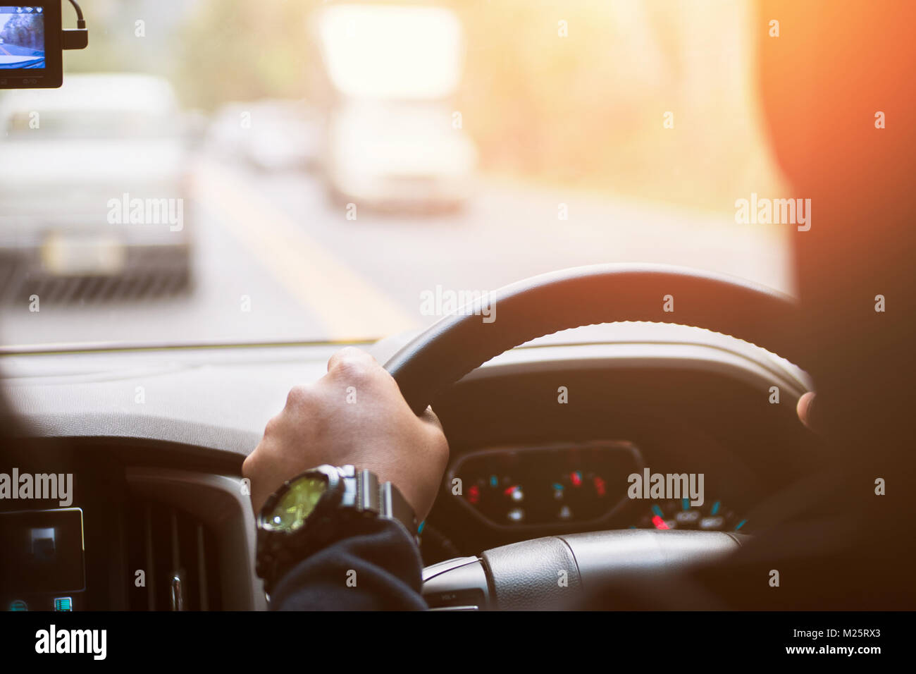 Driver hands holding steering wheel, inside of a car process warm vintage tone Stock Photo