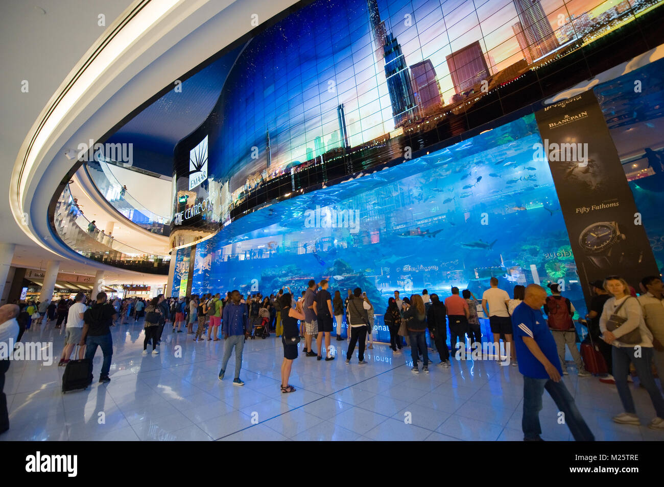 DUBAI, UNITED ARAB EMIRATES - JAN 02, 2018: Tourists are watching at a big aquarium inside the shopping mall in the center of the city near the Burj K Stock Photo