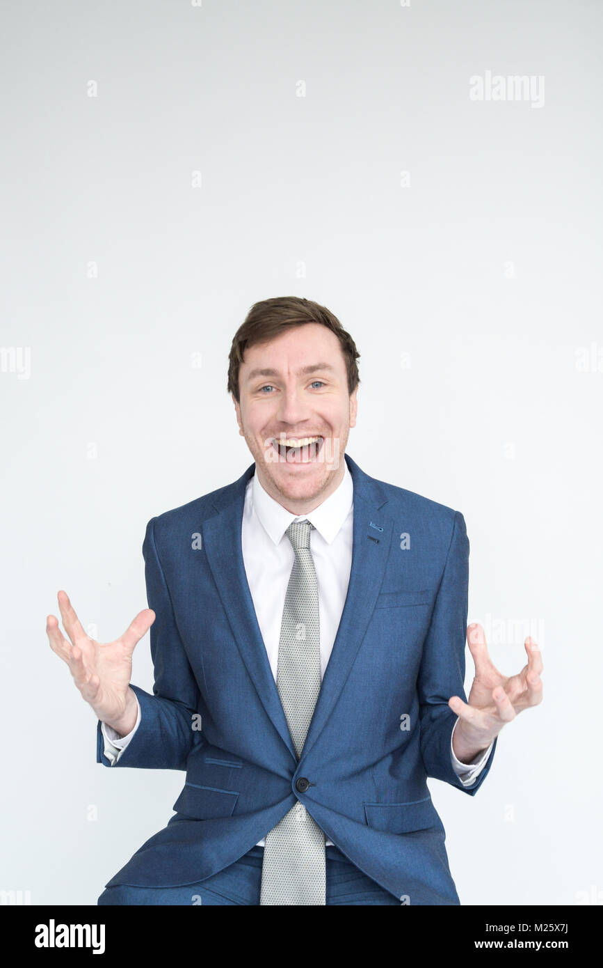 A very excited, well dressed man in a suit punches the air in triumph