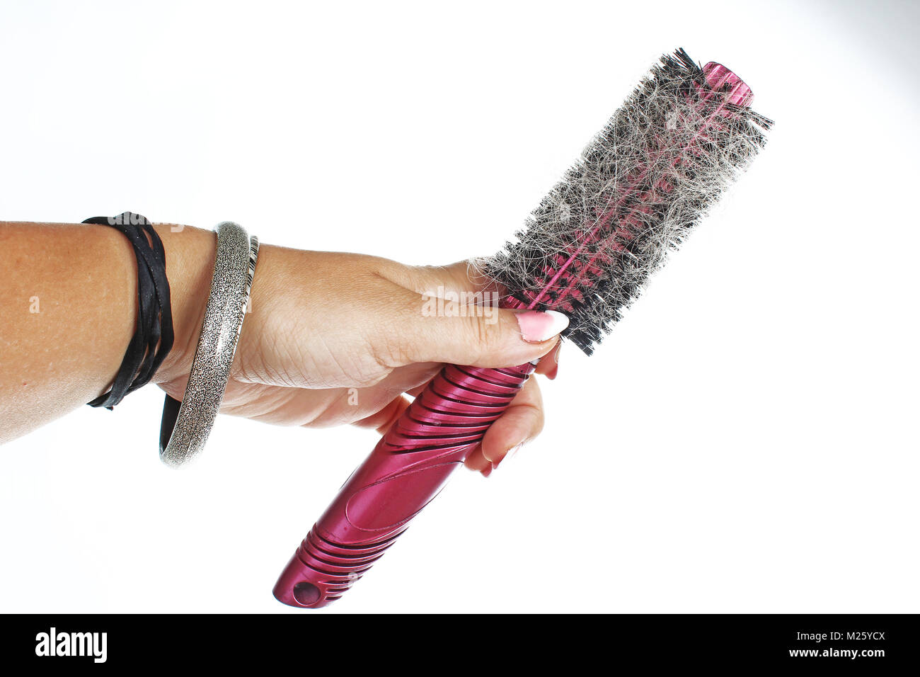 Woman hand holding hairy comb on isolated white background. Studio photo hair loss concept. Stock Photo
