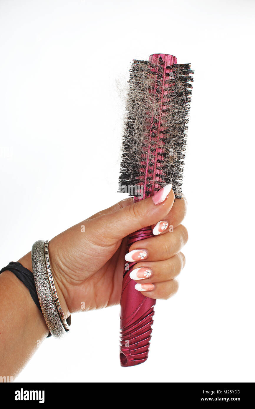 Woman hand holding hairy comb on isolated white background. Studio photo hair loss concept. Stock Photo