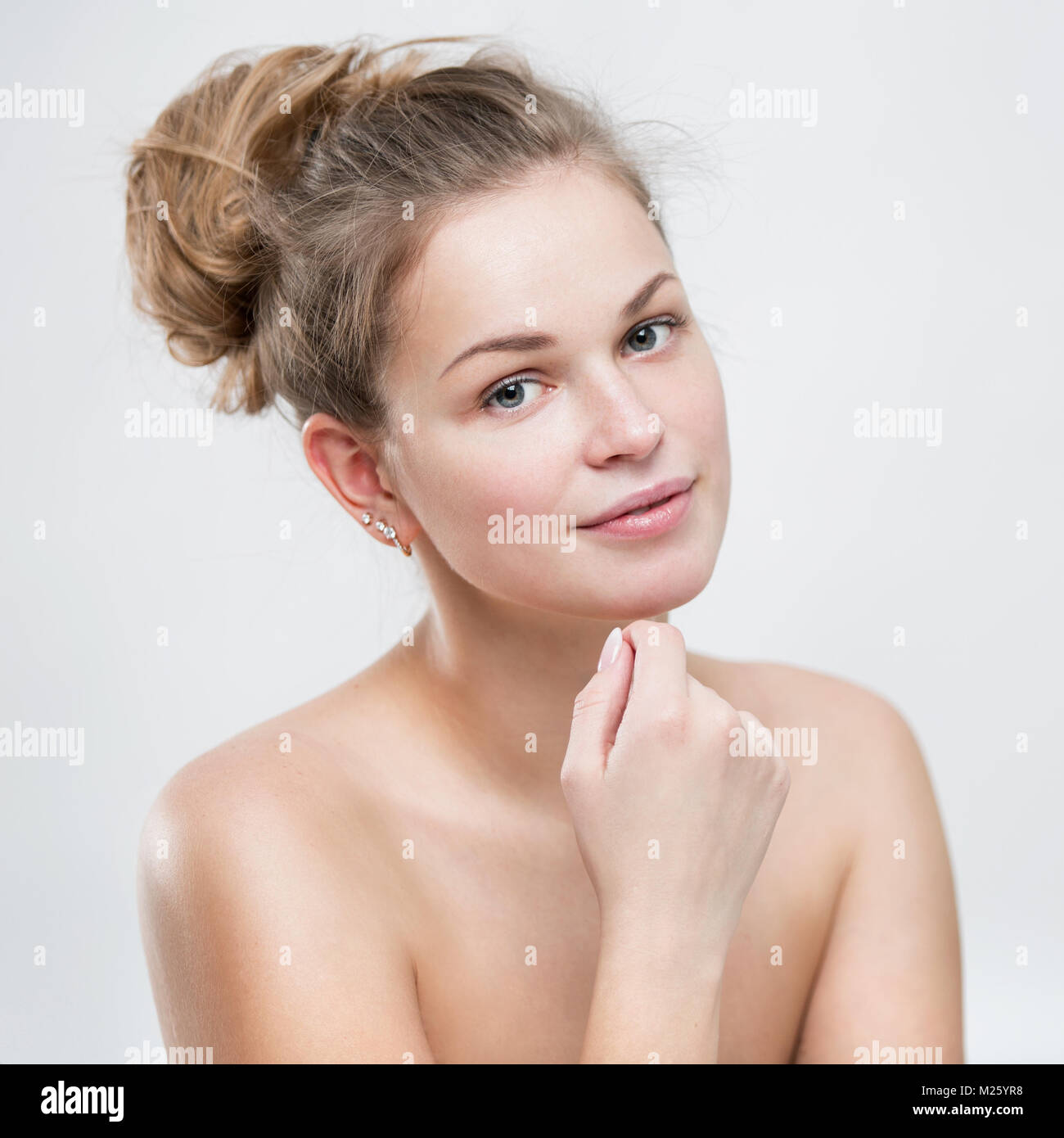 Portrait of a beautiful young woman with facial oil in hands Stock Photo