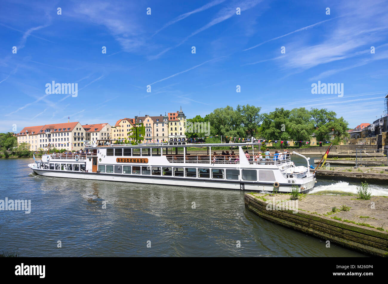 An excursion boat just passed the Steinerne Brücke bridge in Regensburg, Bavaria, Germany. Stock Photo