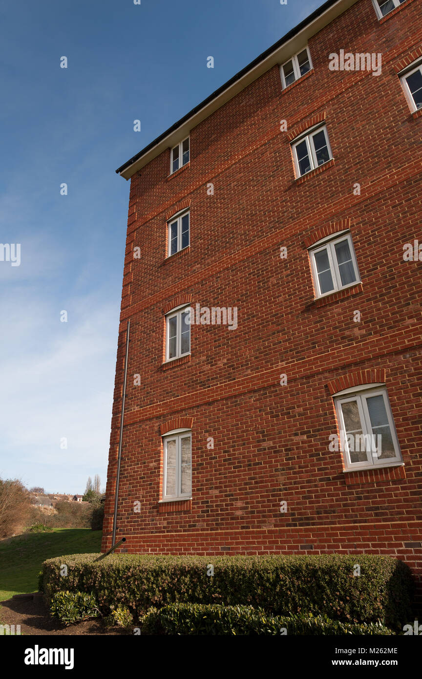 4 floor affordable housing where 3rd 4th floors are missing a drainpipe due to wind damage, creating water and damp problems in brickwork, maintenance Stock Photo