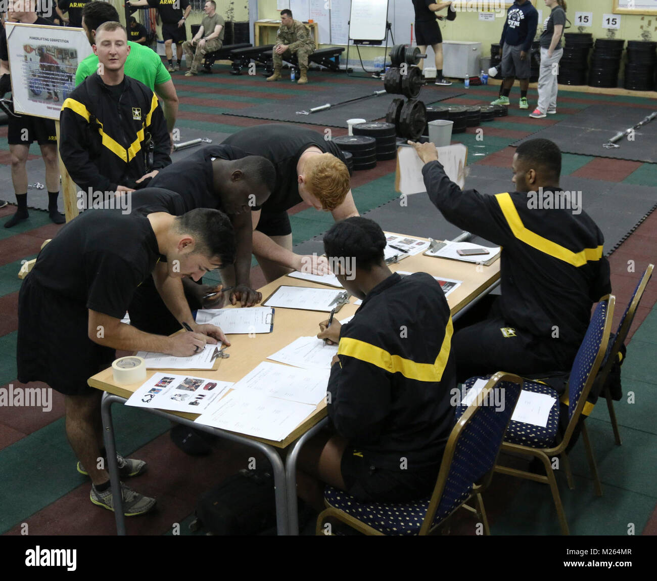 Deployed military members fill out entry forms during the Camp Taji Powerlifting Competition, Camp Taji, Iraq, Jan. 19, 2018. The powerlifting competition is one of many events organized on Camp Taji to improve morale and foster relationships between troops. (U.S. Army Stock Photo