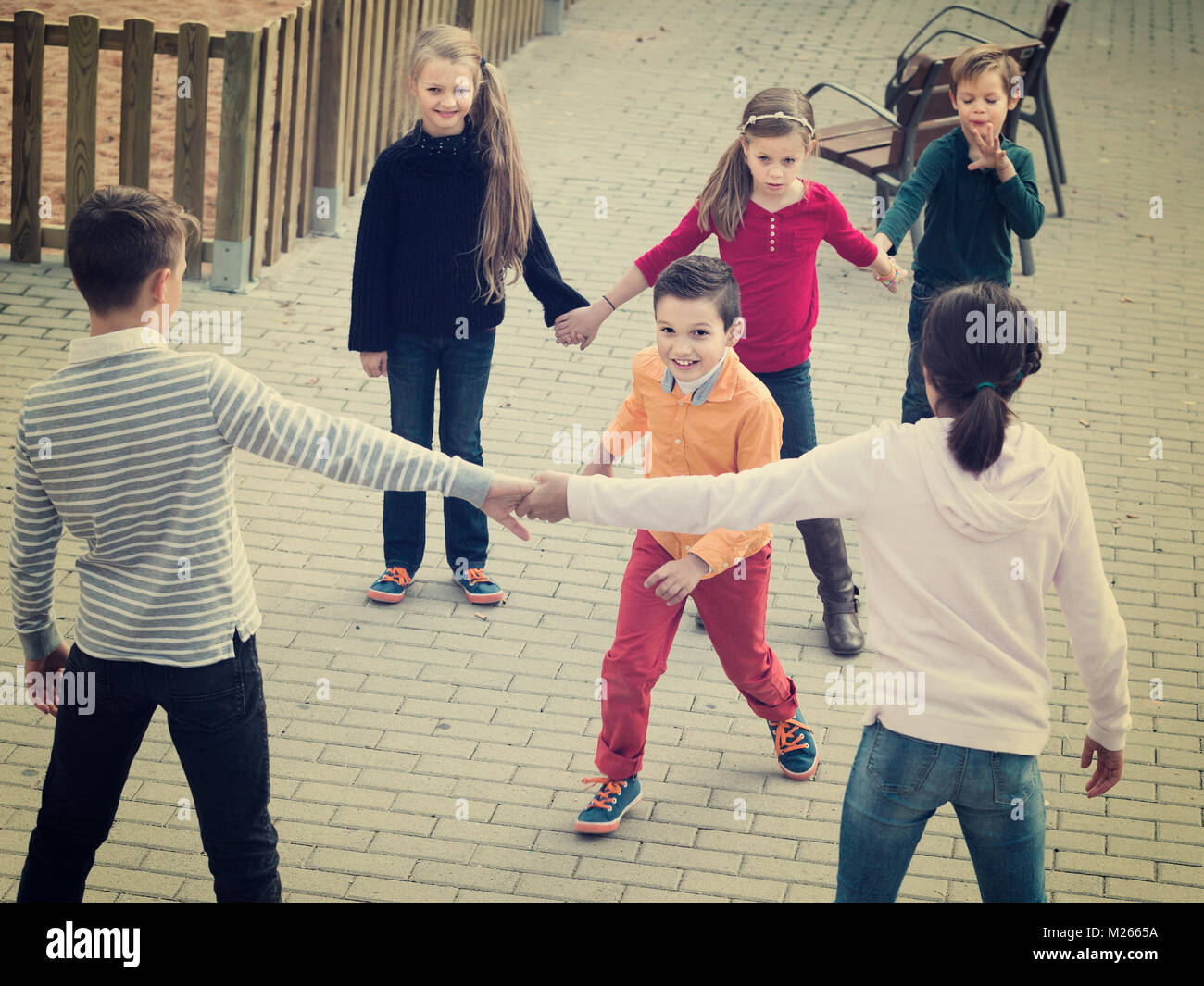 Group of glad children playing red rover outdoors Stock Photo - Alamy