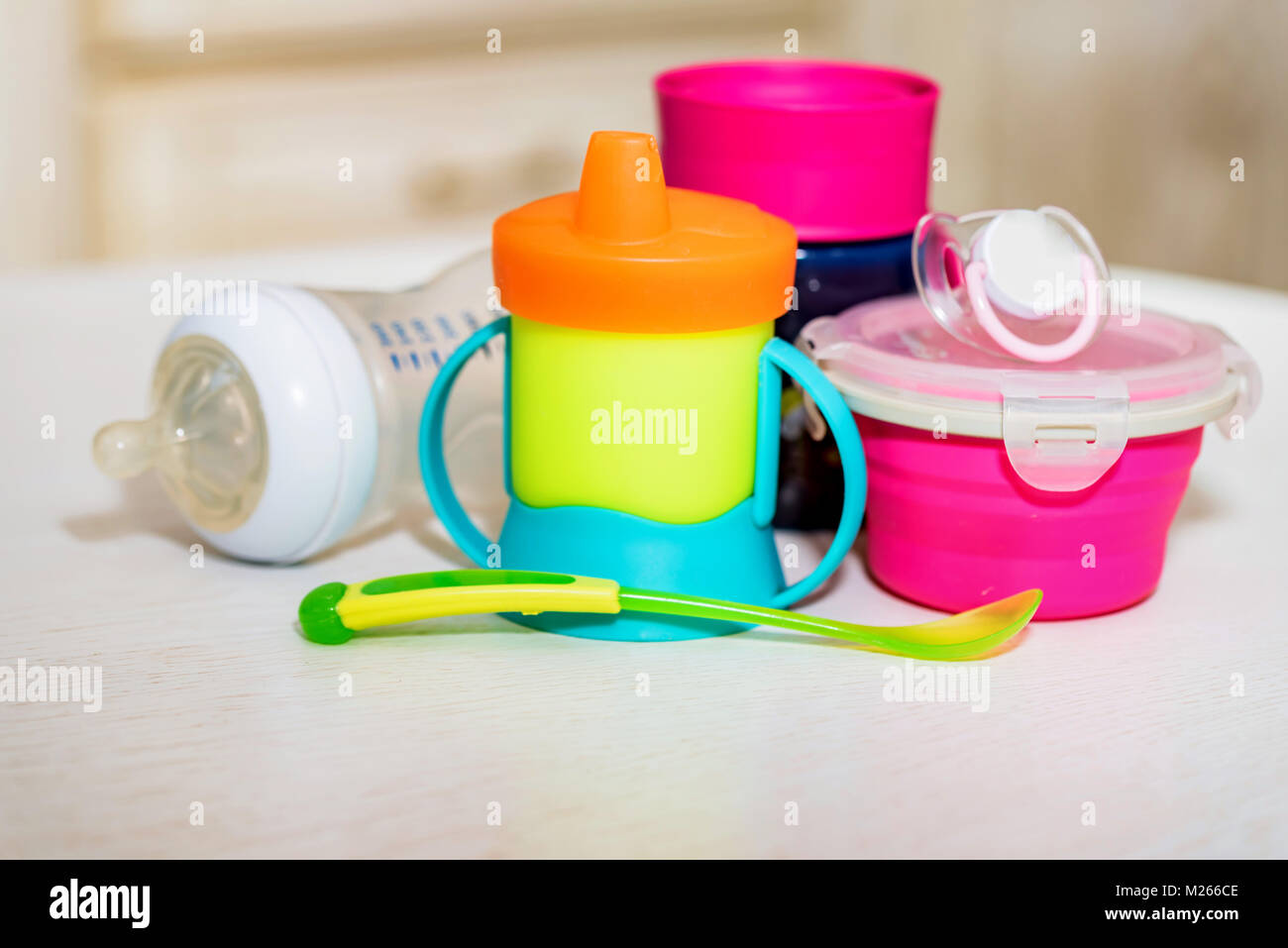 Bright plastic baby dishes on table Stock Photo Alamy