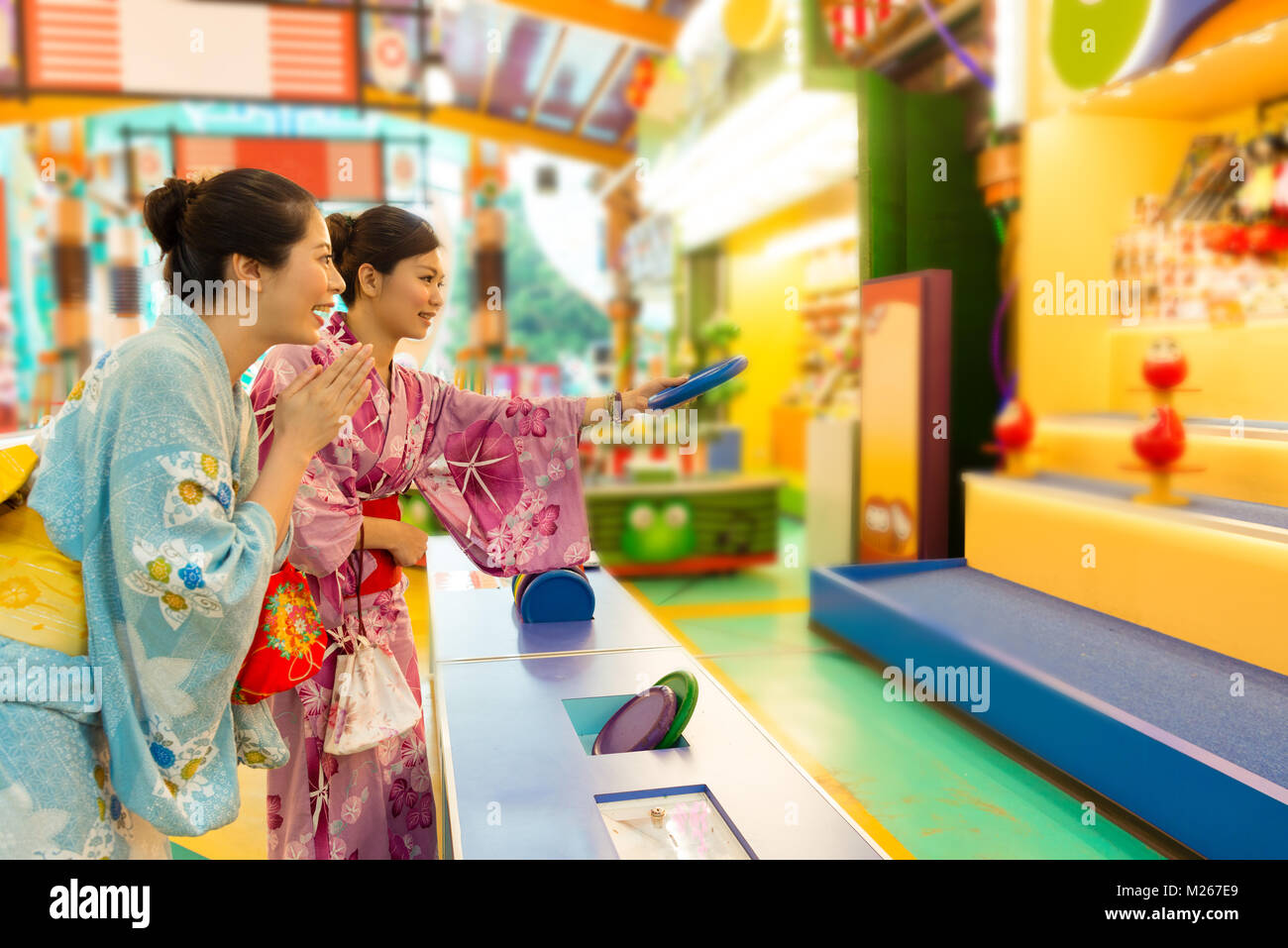 pretty happy girl cheer up when her friends playing hit doll game and they wearing japanese kimono clothing together in japan travel. Stock Photo