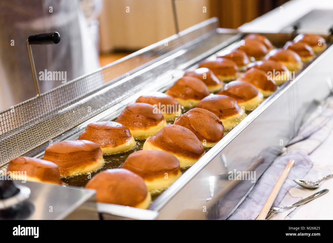 Making homemade jam doughnuts in a professional restaurant buffet