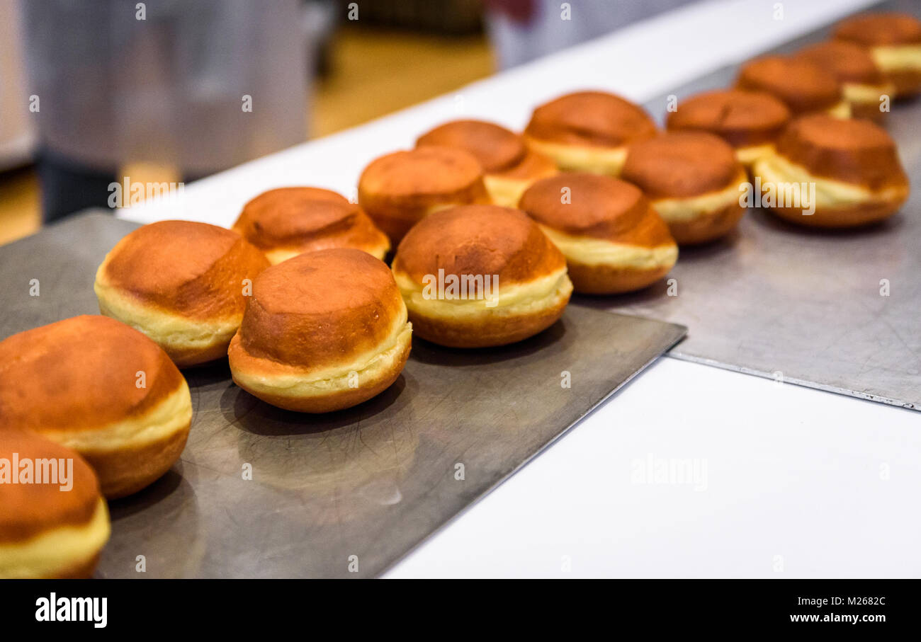 Making homemade jam doughnuts in a professional restaurant buffet kitchen. Deep frying doughnuts