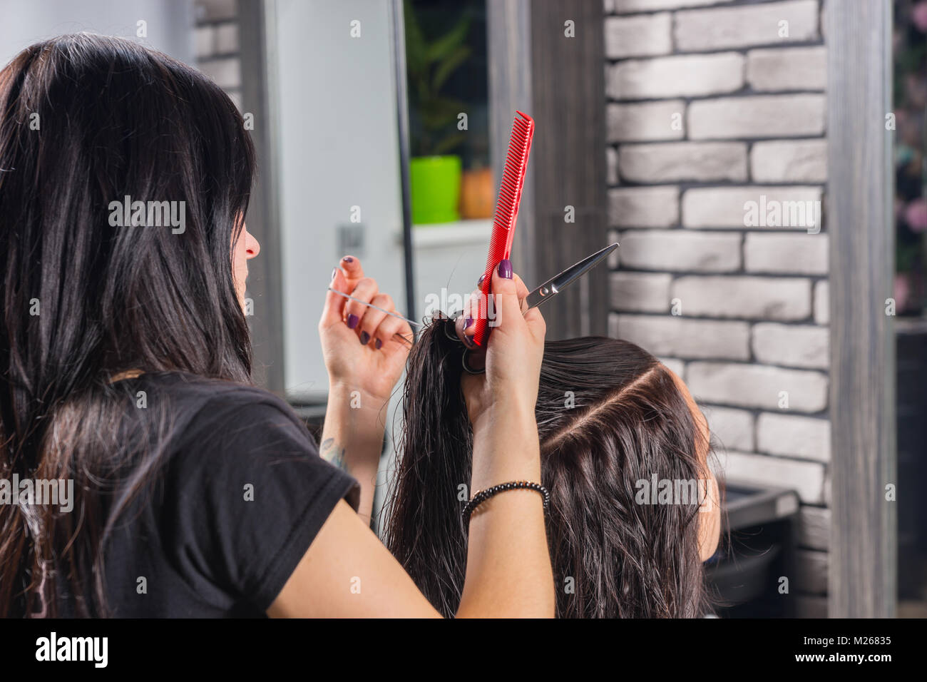 Hair Stylist With Tattooed Hands Cutting And Modeling Brown Hair