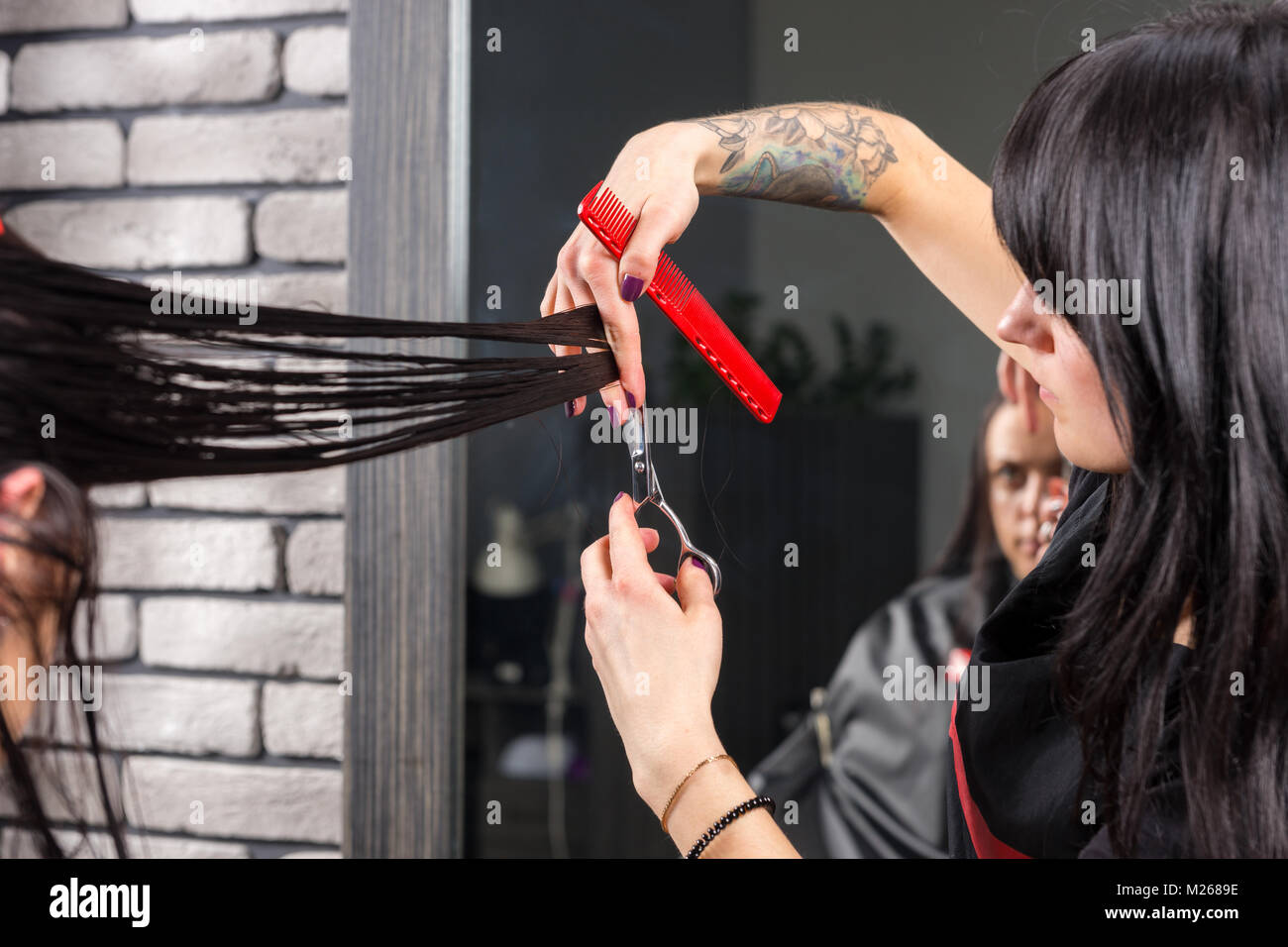 Female Tattooed Stylist S Hands Cutting And Modeling Brown Hair By