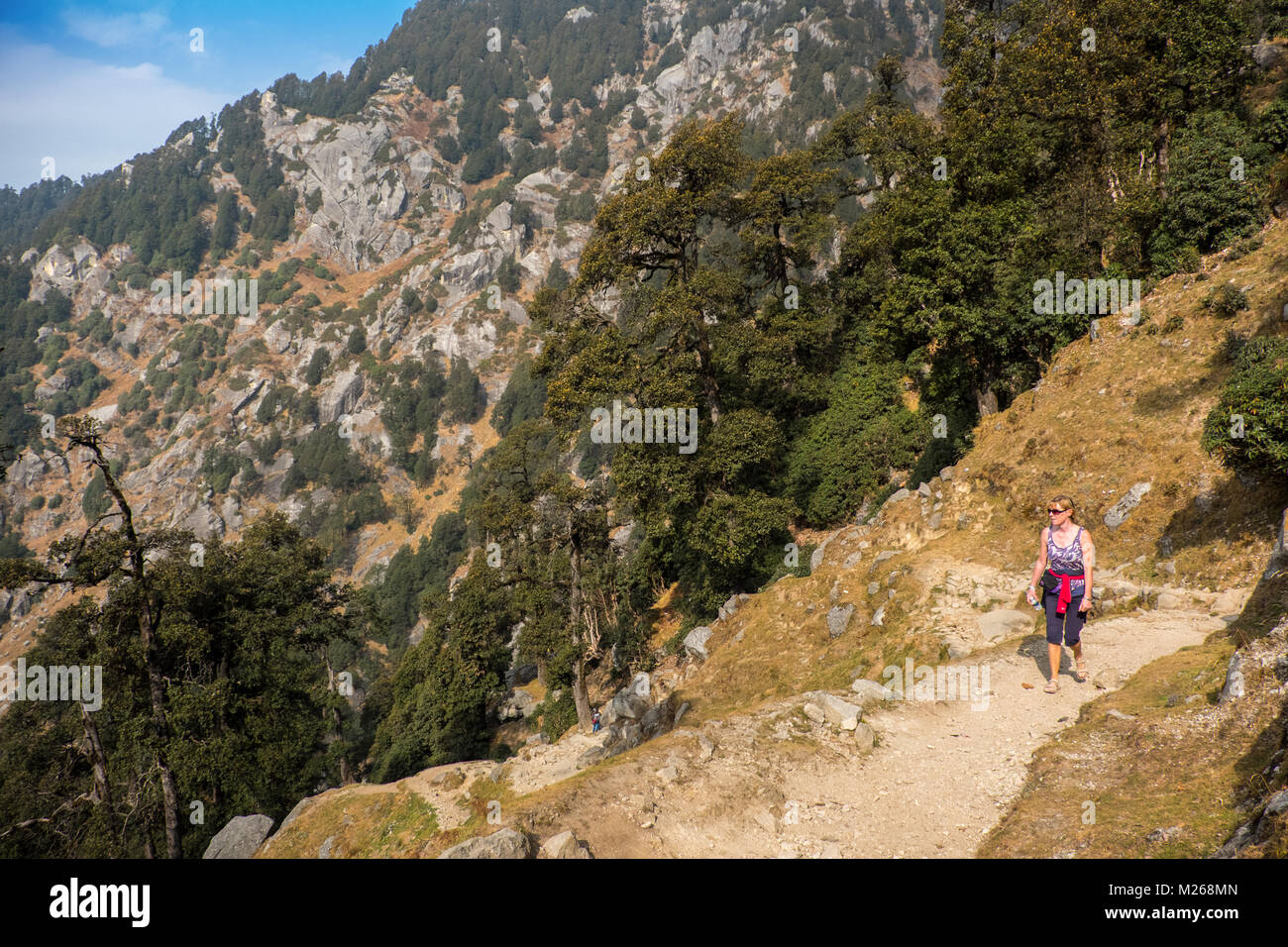 Female western tourist walking on track in the foothills of the Himalayas near Dharamshala, India Stock Photo