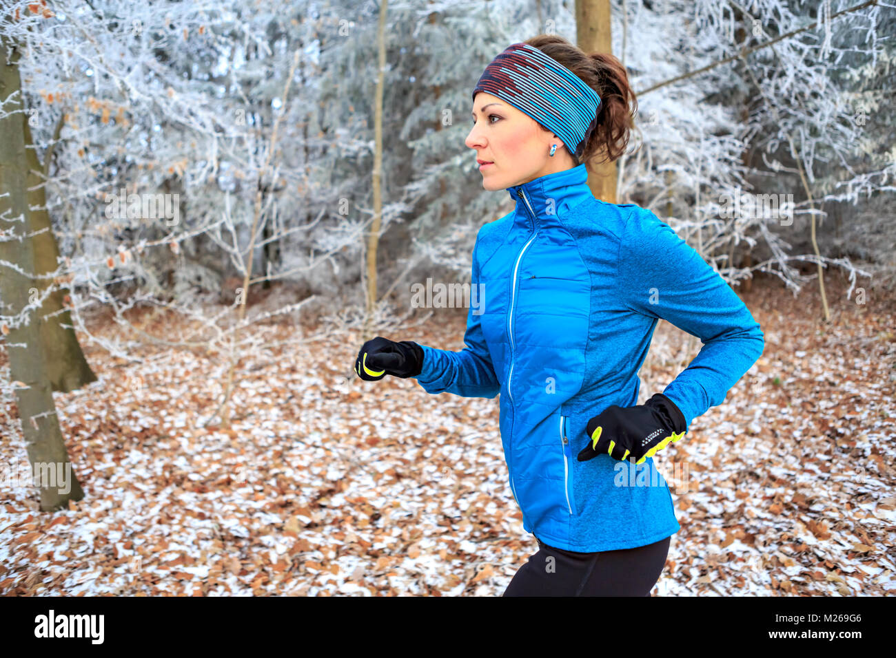 a young woman jogging in the wintry forest Stock Photo - Alamy