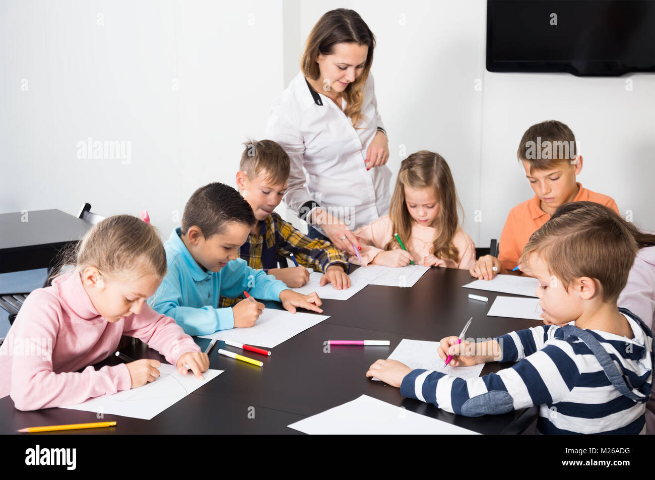 Elementary age children with teacher drawing in classroom on the lesson ...
