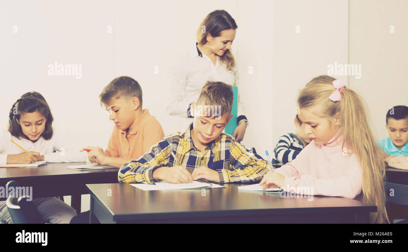 Little children with smiling teacher in classroom Stock Photo - Alamy