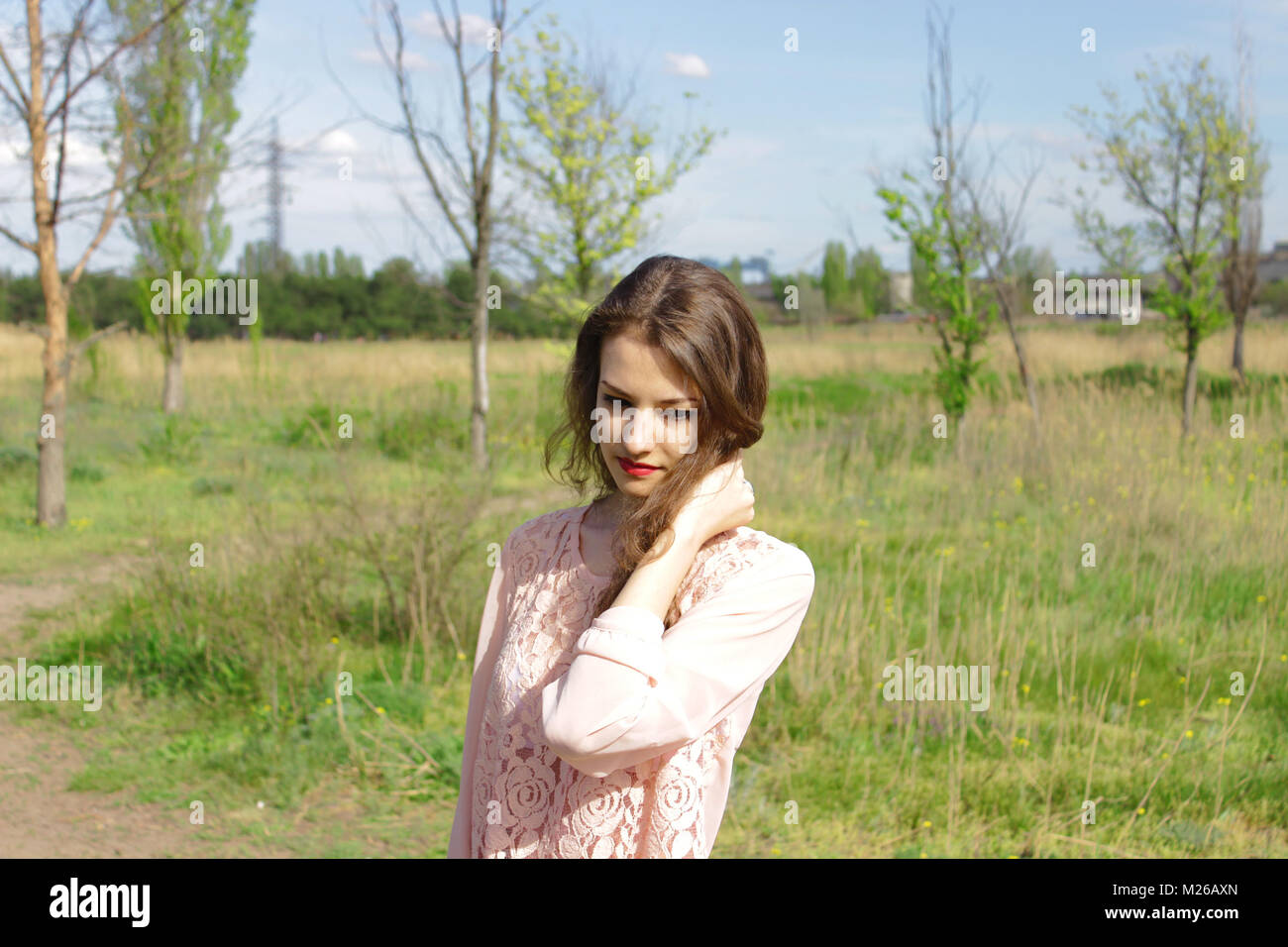 Beautiful girl in a pink dress in field Stock Photo - Alamy