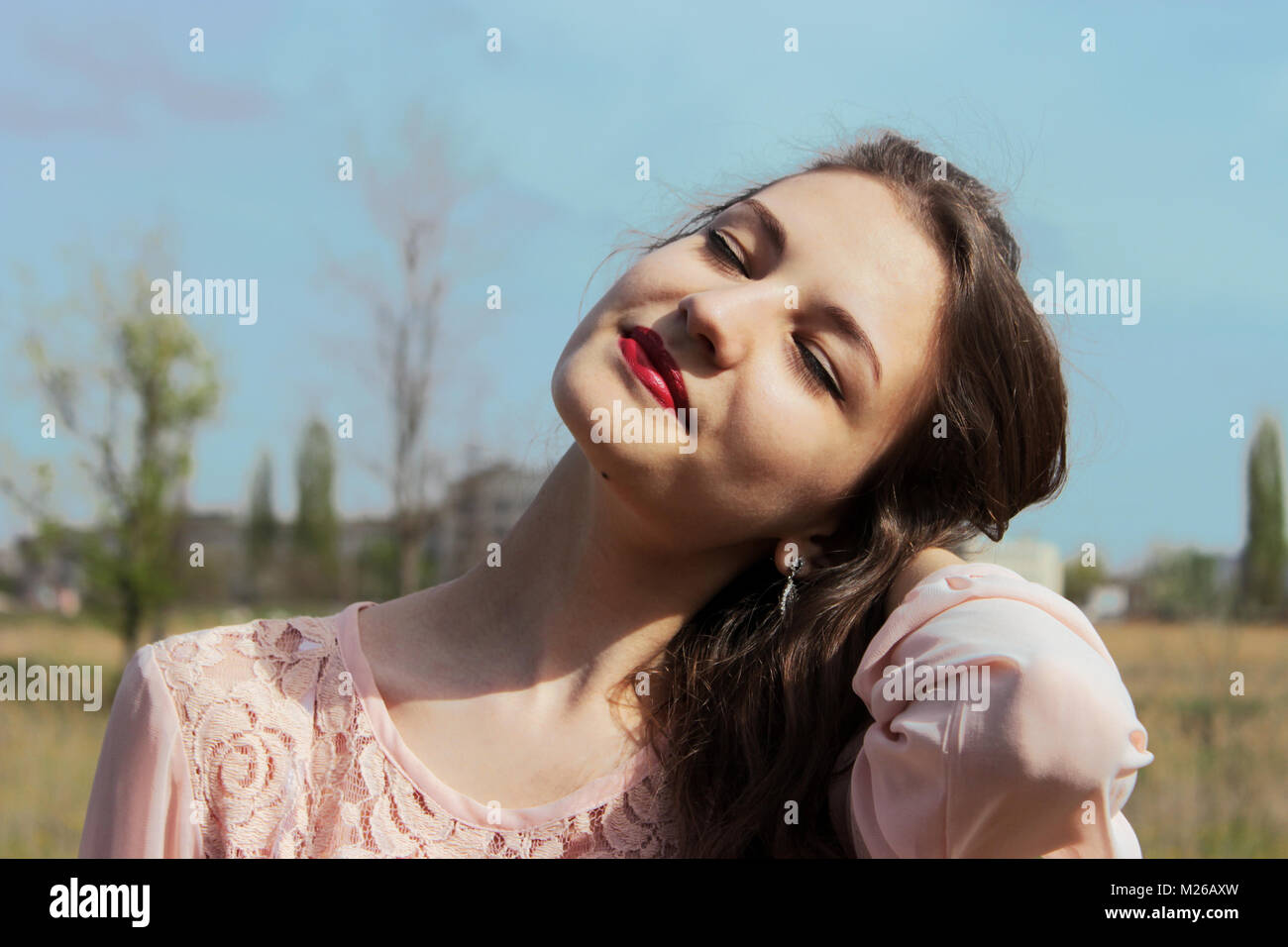 Beautiful girl in a pink dress in field Stock Photo - Alamy