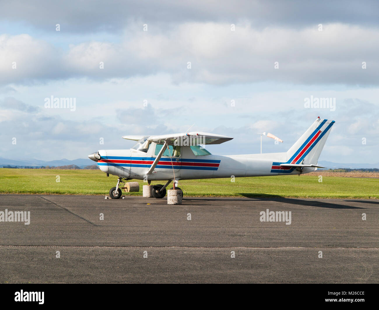 Small sport single-engine plane parked on runway Stock Photo