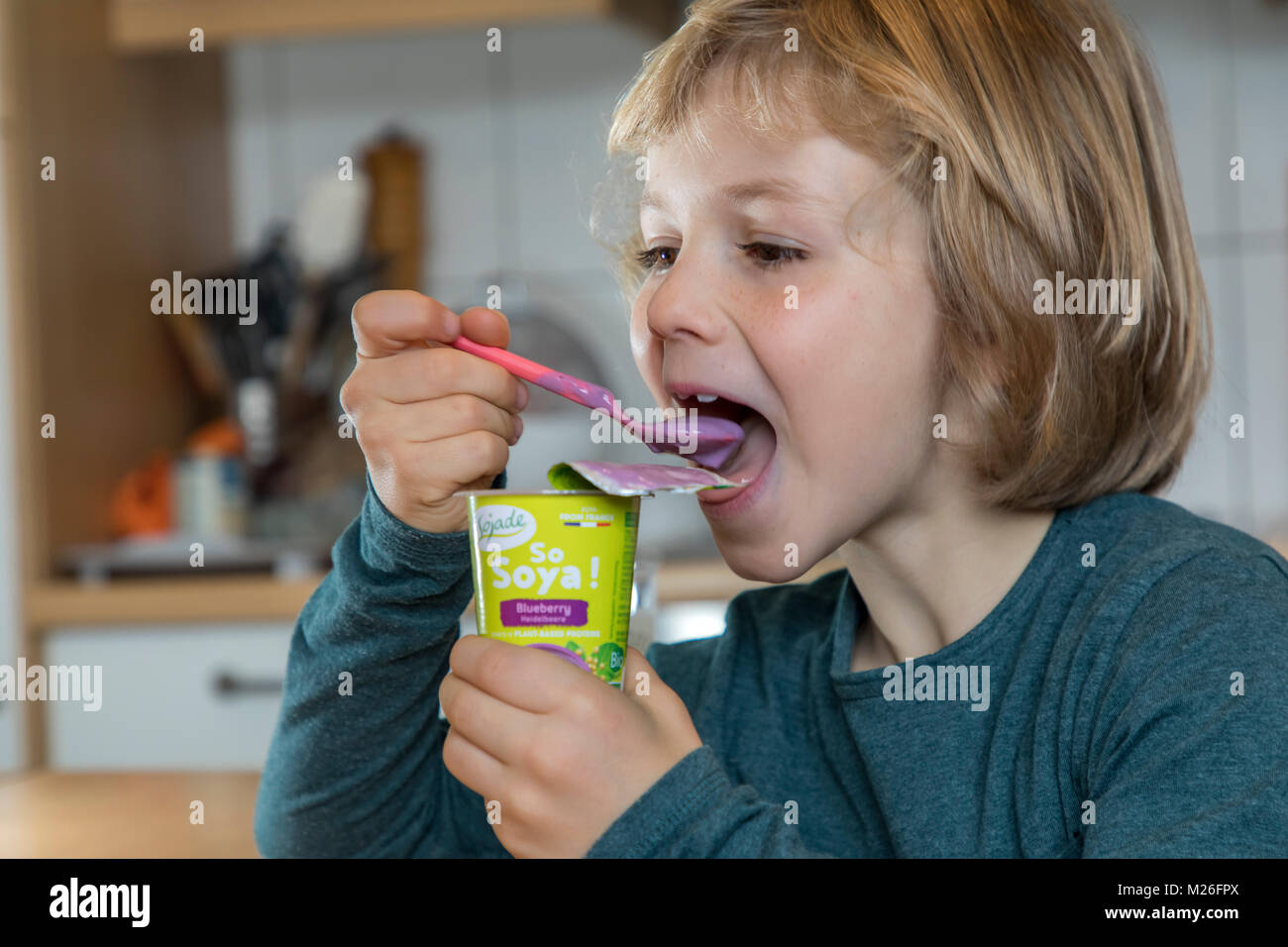 Boy, 7 years old, tastes vegan food, soy fruit yogurt substitute Stock