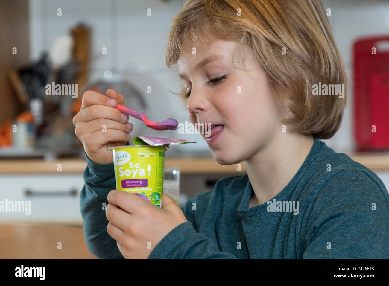 Boy, 7 years old, tastes vegan food, soy fruit yogurt substitute Stock