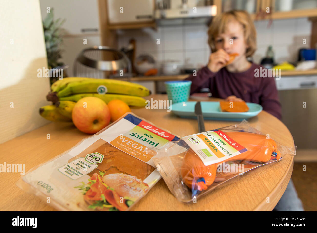 Boy, 7 years old, tasting vegan foods, sausage replacement products, vegan salami, vegan meat sausage, Stock Photo