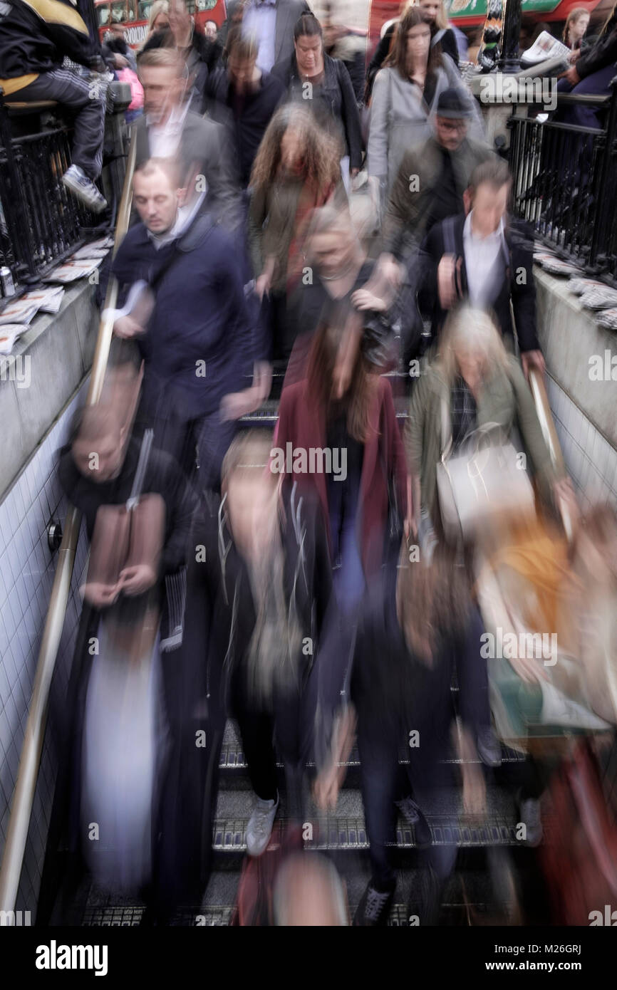 London street photography: blurred figures descending steps to tube station. Stock Photo