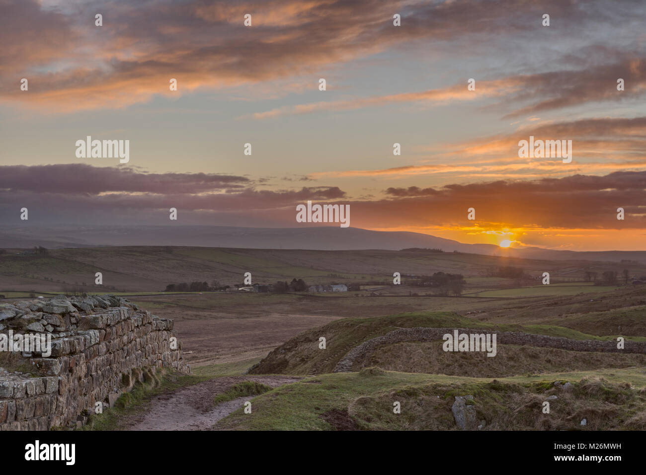 Hadrian's Wall: a winter view to the west, looking over Sycamore Gap (between Highshield and Peel Crags) at sunset, with Cold Fell in the distance Stock Photo