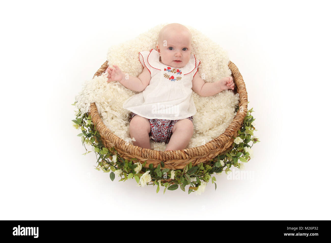 beautiful 3 month old baby girl happy playing in basket Stock Photo