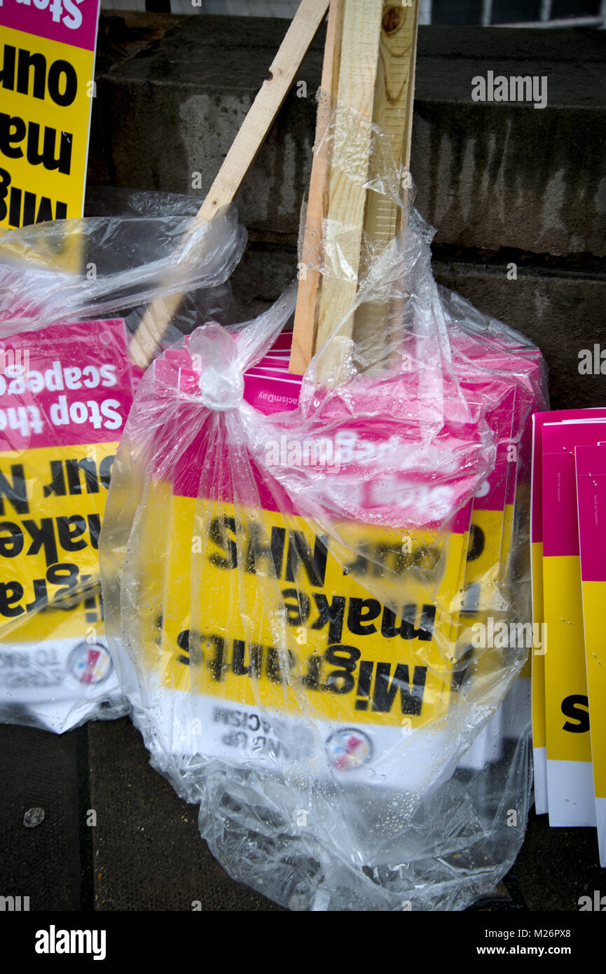 Demonstration called by the People's Assembly in support of the NHS . Placards wrapped in plastic saying 'Migrants make our NHS'. Stock Photo