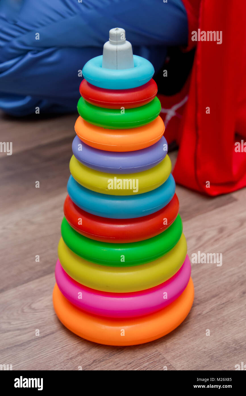 Colorful plastic rainbow toy pyramid for little kids on the blue background. Children's bright multi-colored toys. Children's multi-colored rainbow to Stock Photo