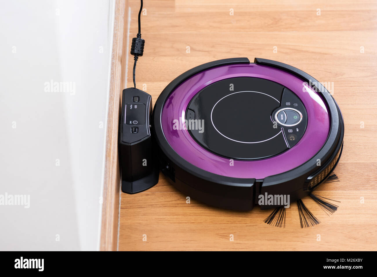 robotic vacuum cleaner charging battery at charging dock Stock Photo