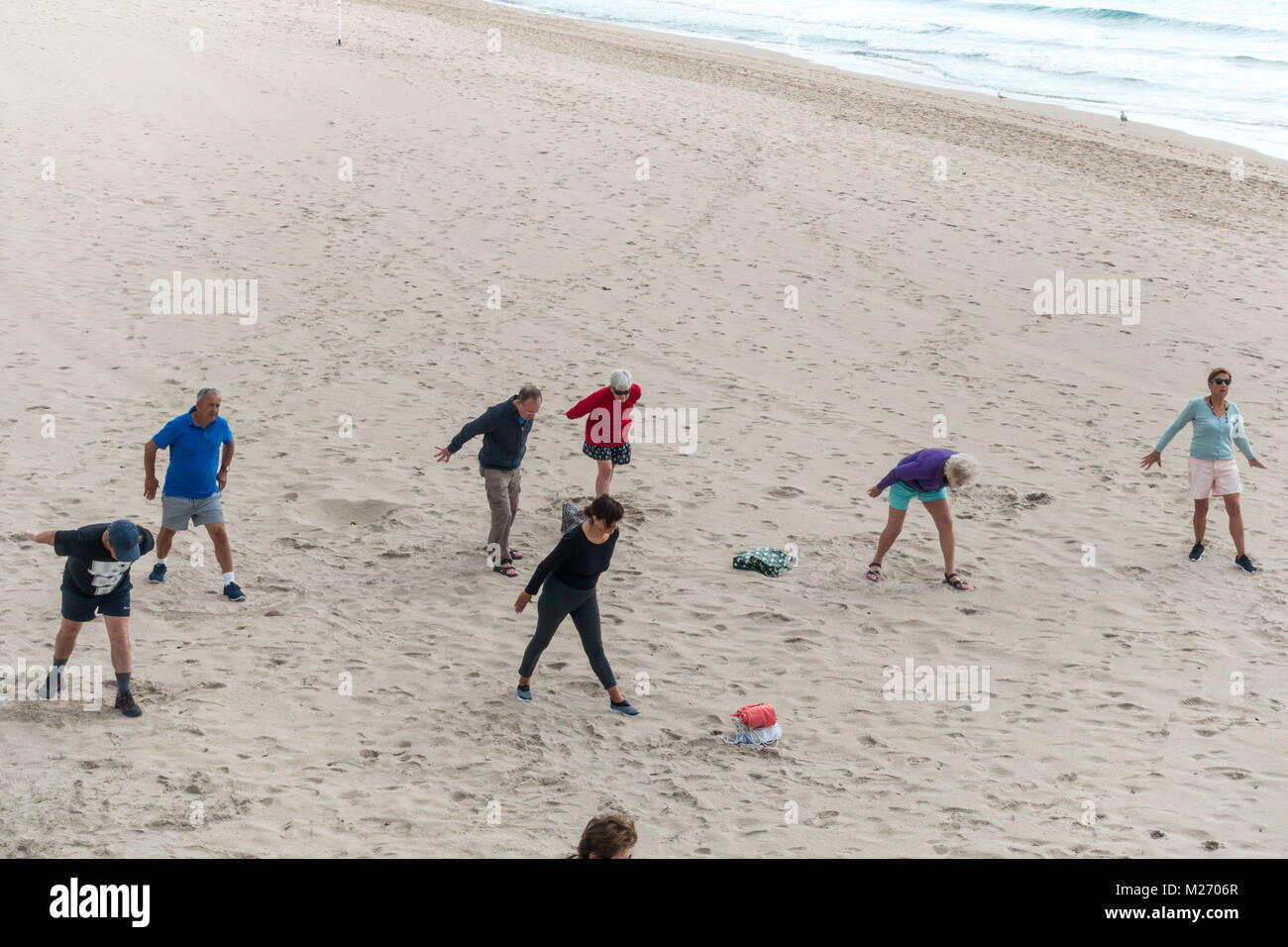 Seniors keeping fit on the beach in Benidorm, Spain. Men women oap's, elderly fitness class Stock Photo