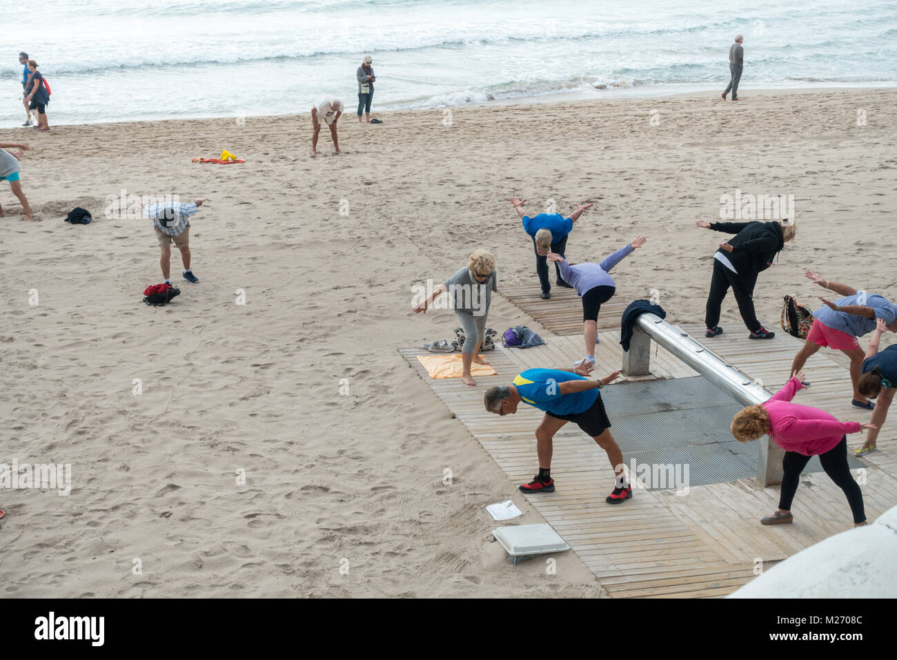 Seniors keeping fit on the beach in Benidorm, Spain. Men women oap's, elderly fitness class Stock Photo