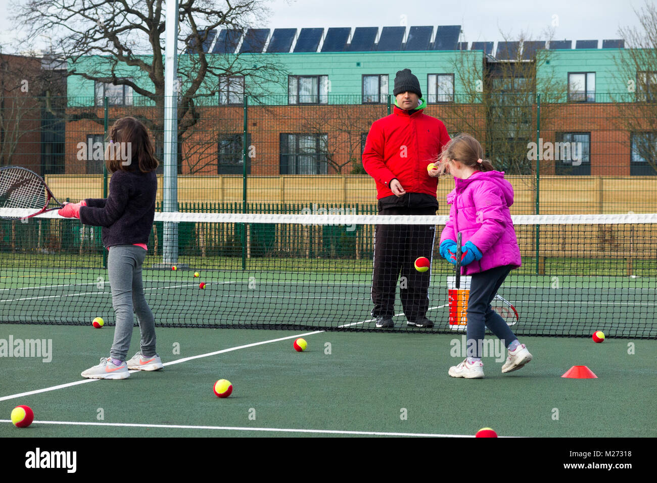 Children's tennis coaching session / lesson taking place on a fullsize