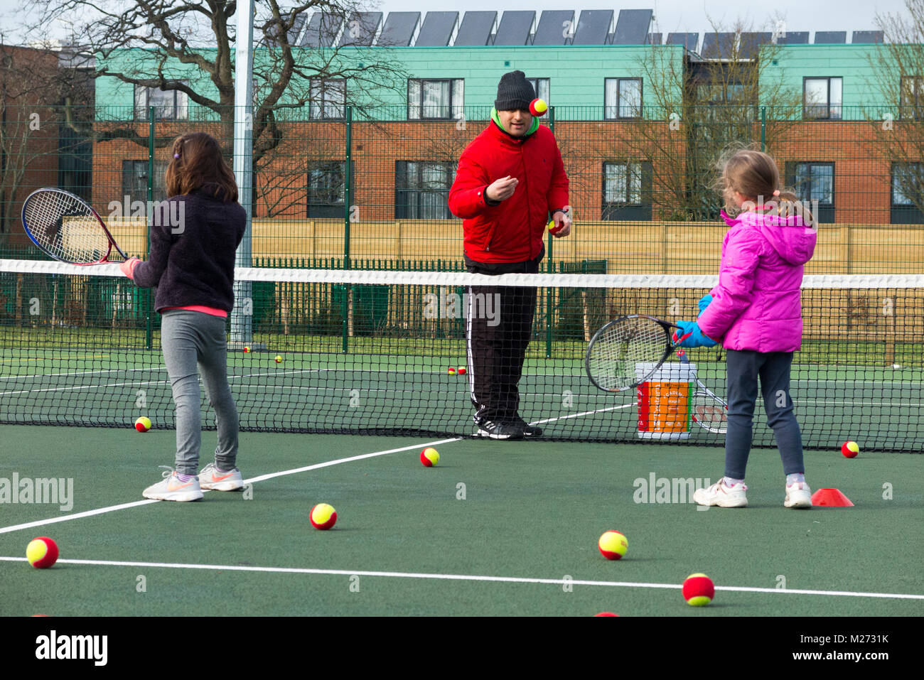 Children's tennis coaching session / lesson taking place on a fullsize