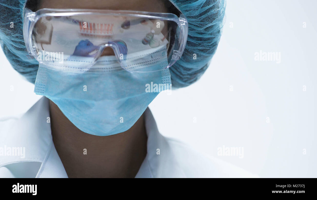 Mixed-race chemist working in security goggles, conducting experiment, close-up Stock Photo