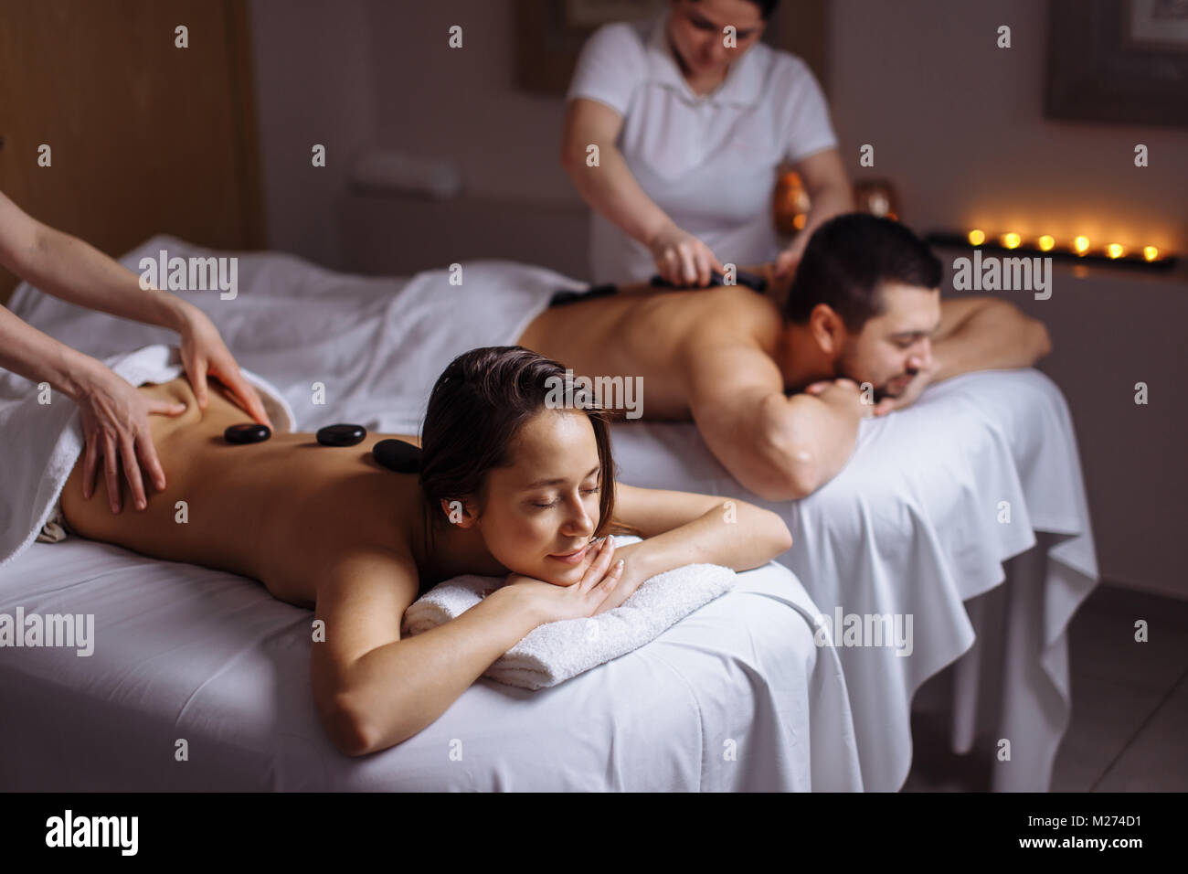 couple in spa salon having hot stone massage Stock Photo - Alamy