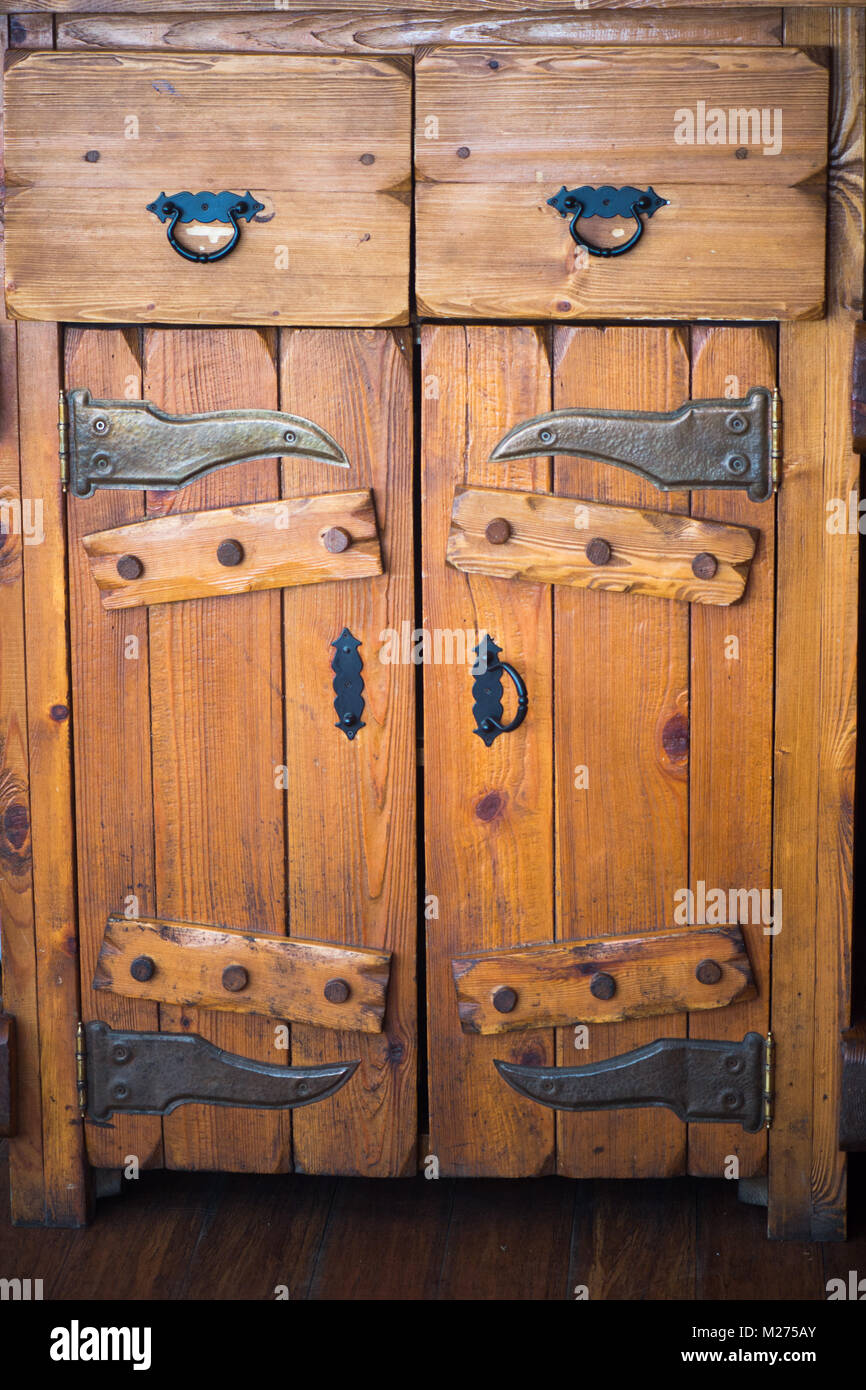 Antique solid wooden Cabinet with doors and drawers.Black metal forged fittings Stock Photo