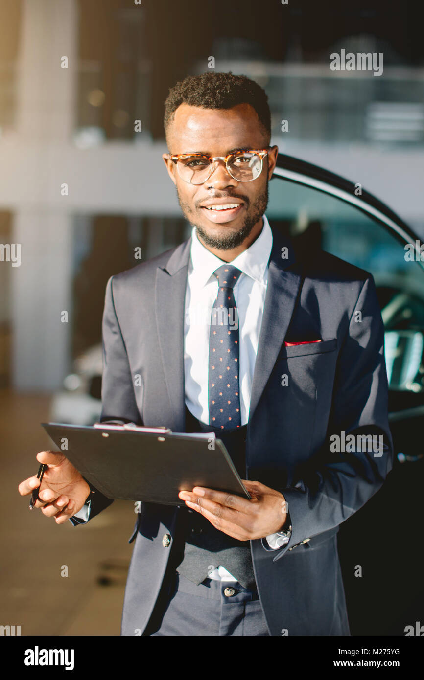 Handsome African Car Salesman Standing At The Dealership Holding A Tablet Stock Photo Alamy