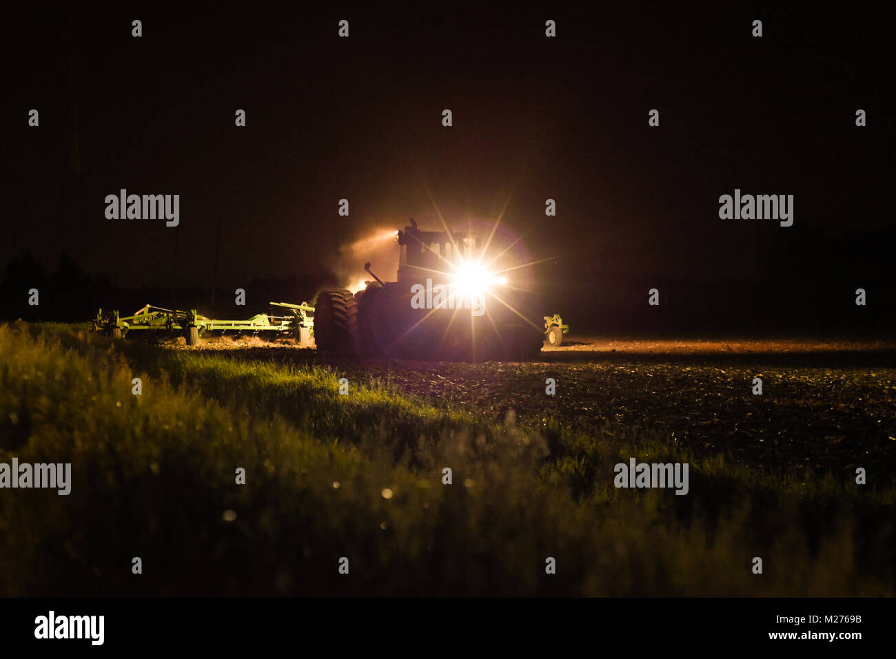 Farmer working the field at night Stock Photo