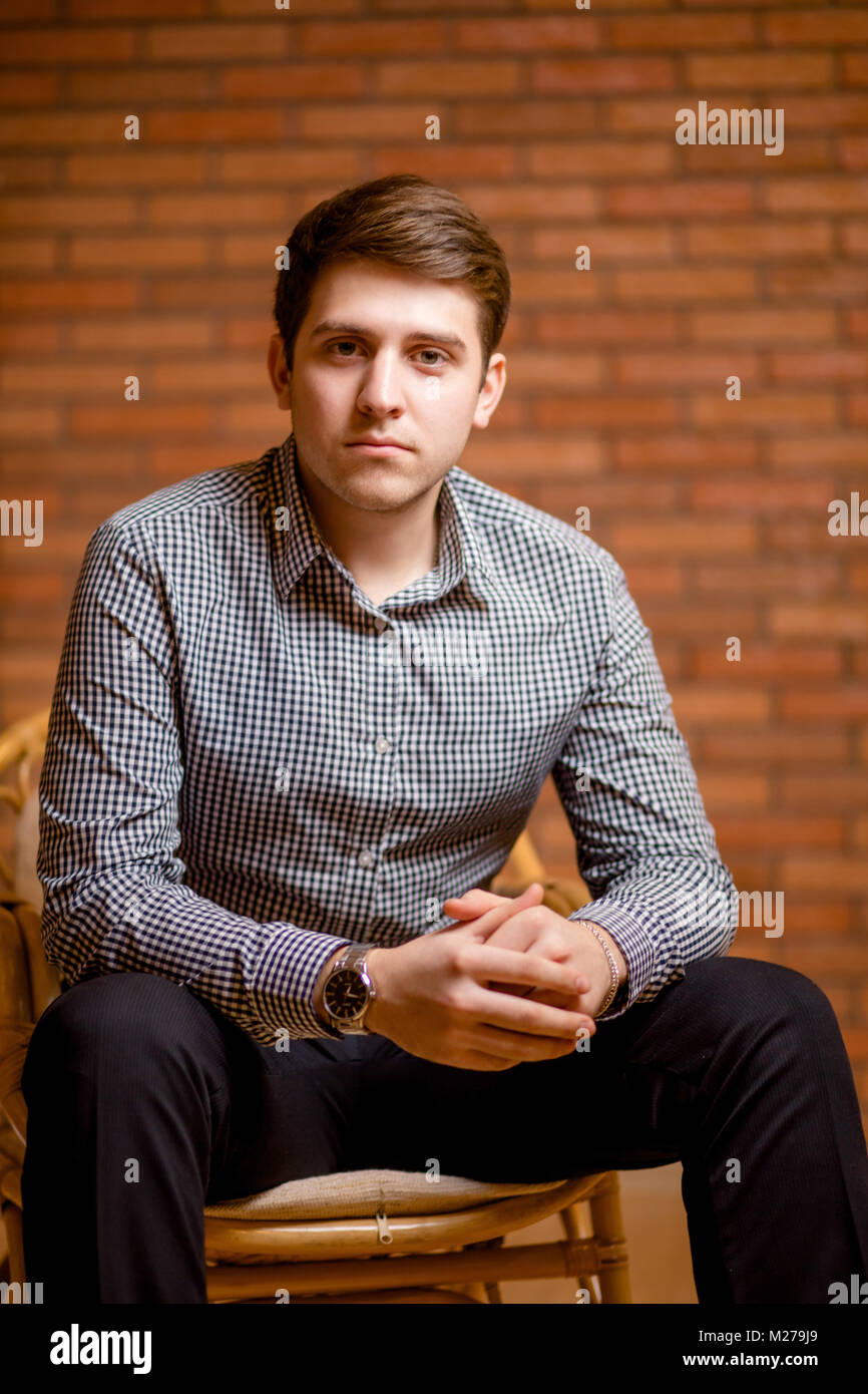 Smiling Young Man Leaning Against Brick Wall Stock Photo - Alamy