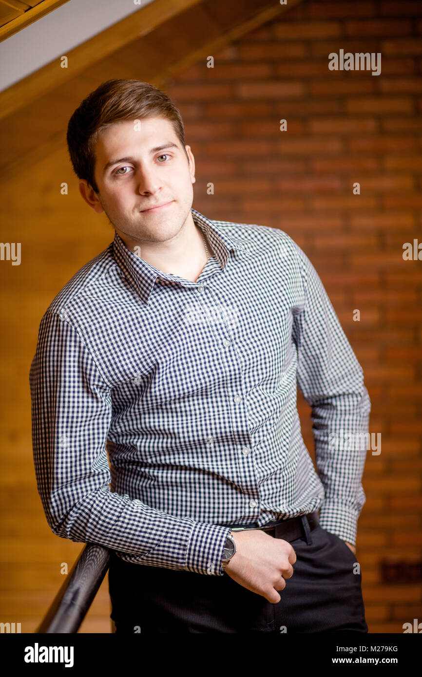 Smiling Young Man Leaning Against Brick Wall Stock Photo - Alamy